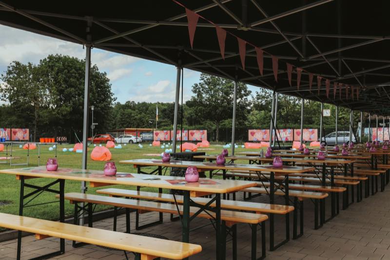 Biertischgarnituren unter dem Pavillon mit Blick auf die Wiese