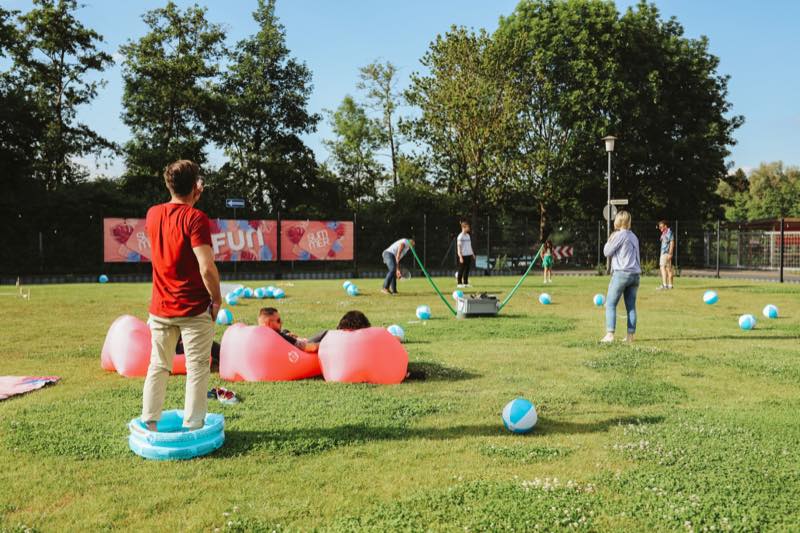 Gäste auf der Wiese mit Sitzsäcken und Wasserbällen