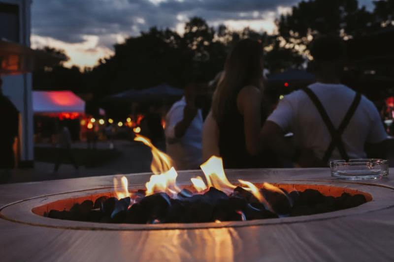 Feuertisch mit Gästen in der Abenddämmerung